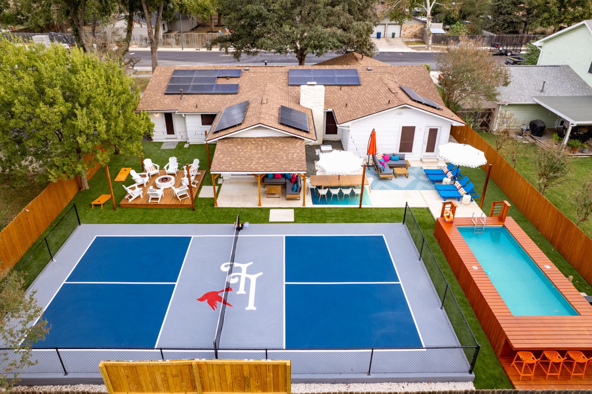 Aerial view of pickleball court, pool, and outdoor living