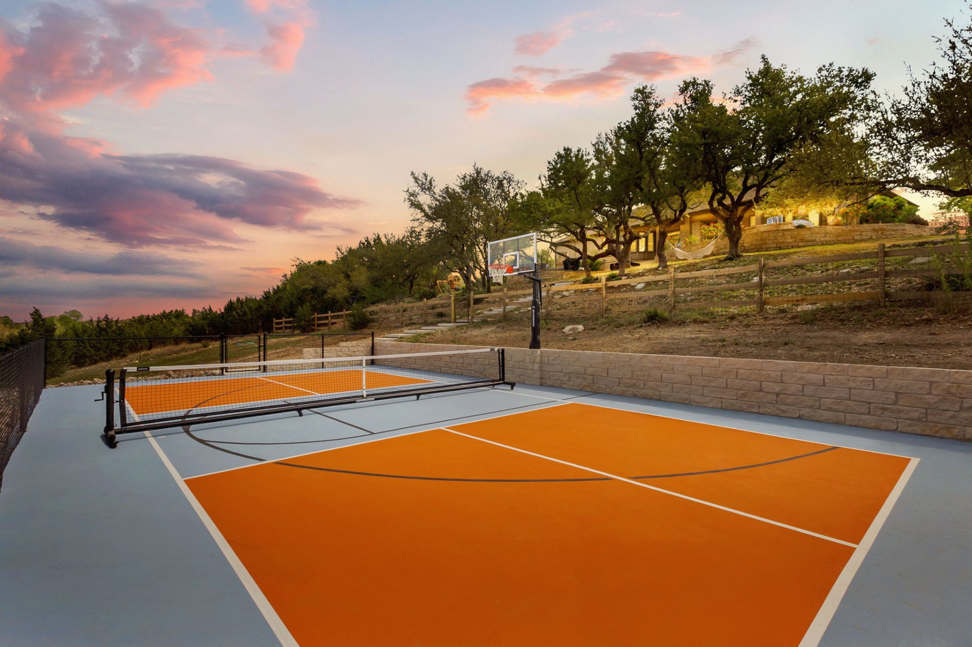 Hill country pickleball and basketball court at sunset